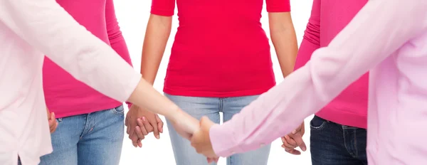 Close up of women in pink shirts holding hands — Stock Photo, Image