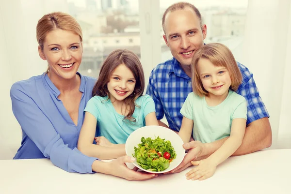Happy family with two kids with salad at home — Stock Photo, Image