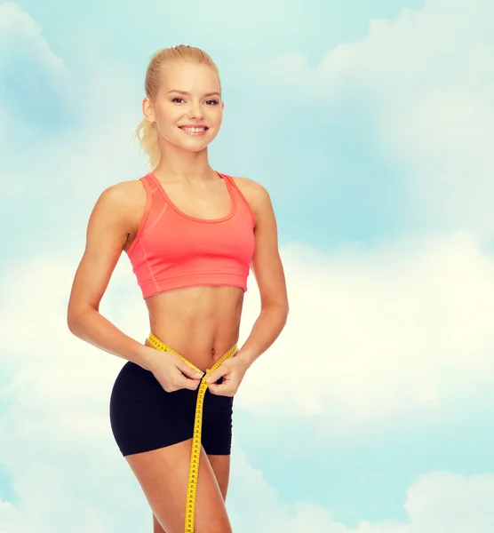 Sorrindo mulher desportiva com fita métrica — Fotografia de Stock