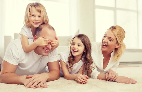 Parents et deux filles couchés sur le sol à la maison — Photo