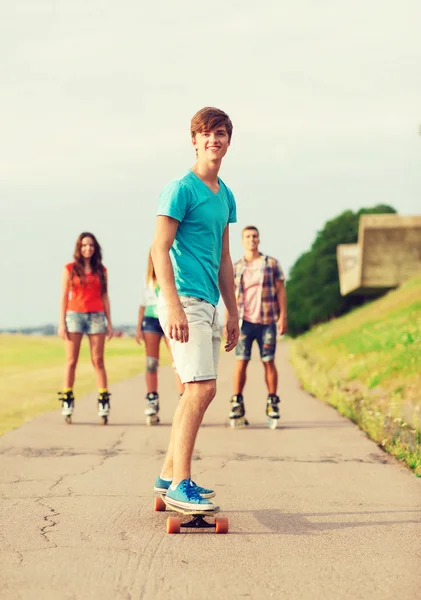 Grupp leende tonåringar med roller-skates — Stockfoto