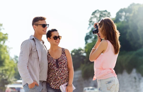 Amigos felices con la cámara tomando fotos al aire libre — Foto de Stock