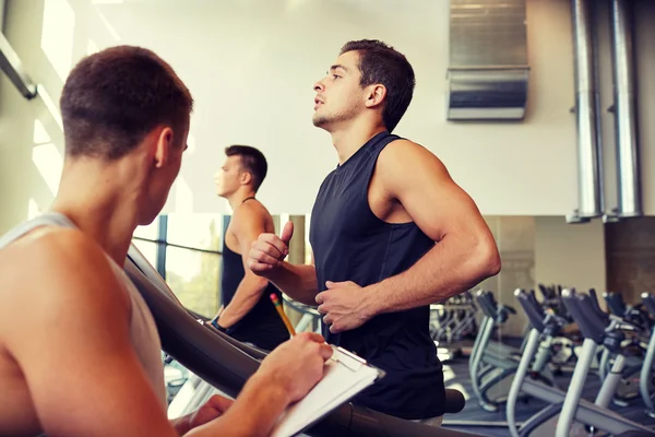 Männer trainieren auf Laufband im Fitnessstudio — Stockfoto