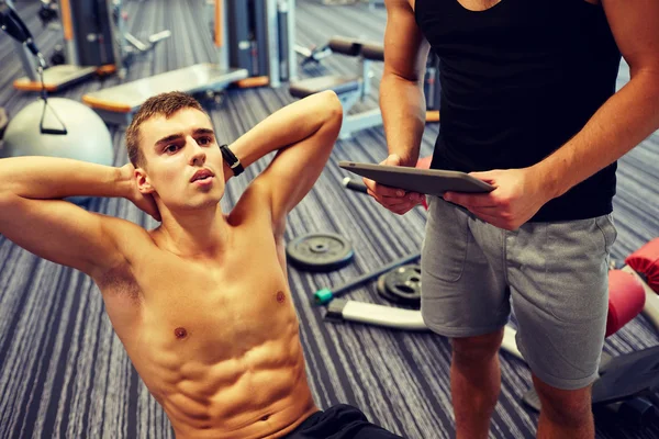 Hombres flexionando los músculos abdominales en el gimnasio —  Fotos de Stock