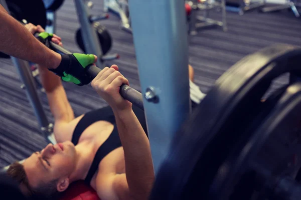 Två unga män med skivstång flexar muskler i gymmet — Stockfoto