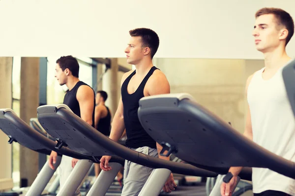 Groep mannen uitoefenen op loopband in de sportschool — Stockfoto