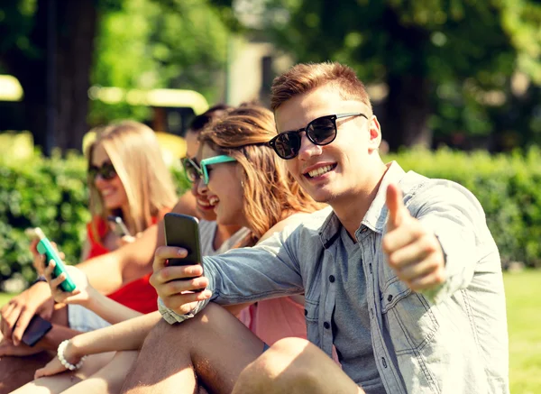Sorrindo homem com smartphone mostrando polegares para cima — Fotografia de Stock