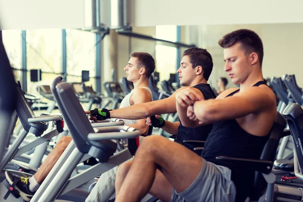 Männer trainieren auf Heimtrainer im Fitnessstudio — Stockfoto