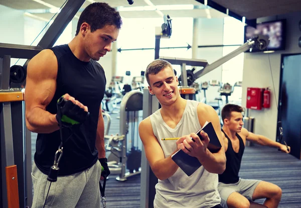 Los hombres que hacen ejercicio en la máquina de gimnasio — Foto de Stock