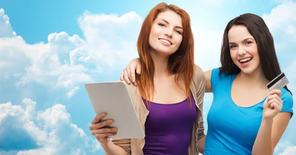 Dos chicas sonrientes con tablet PC y tarjeta de crédito — Foto de Stock