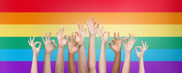 Hands showing ok sign over rainbow background — Stockfoto