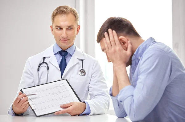 Doctor and patient with cardiogram on clipboard — Stockfoto