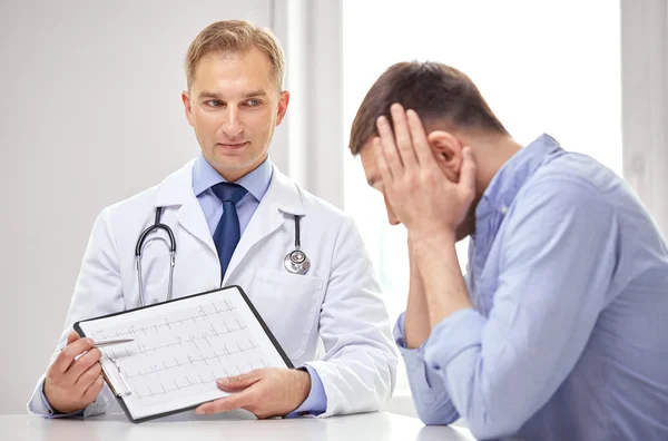 Doctor and patient with cardiogram on clipboard — Φωτογραφία Αρχείου