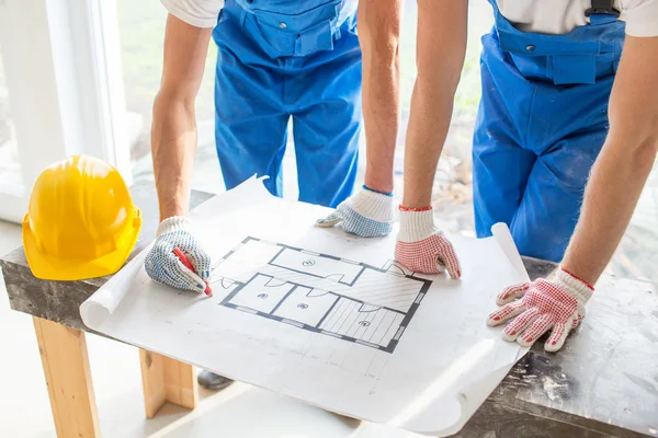 Close up of builders discussing blueprint — Stockfoto