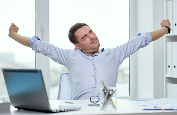 Uomo d'affari annoiato con computer portatile e carte in ufficio — Foto Stock