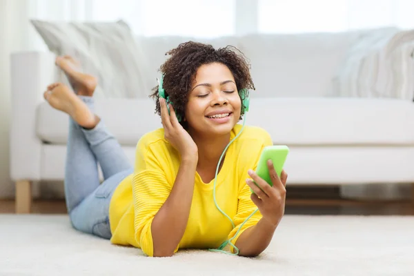 Mulher africana feliz com smartphone e fones de ouvido — Fotografia de Stock