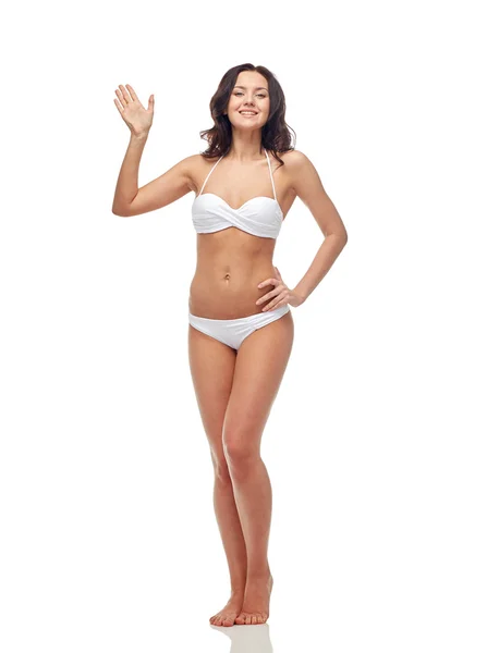 손을 흔들며 흰색 수영복에 행복 한 젊은 여자 — 스톡 사진