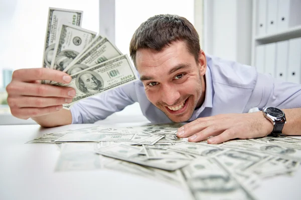 Šťastný podnikatel s haldy peněz v úřadu — Stock fotografie