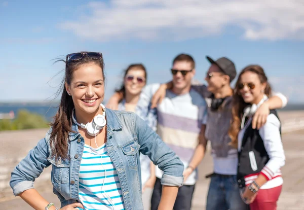 Teenager-Mädchen mit Kopfhörern und Freunden draußen — Stockfoto