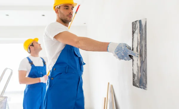 Two builders with painting tools repairing room — 图库照片