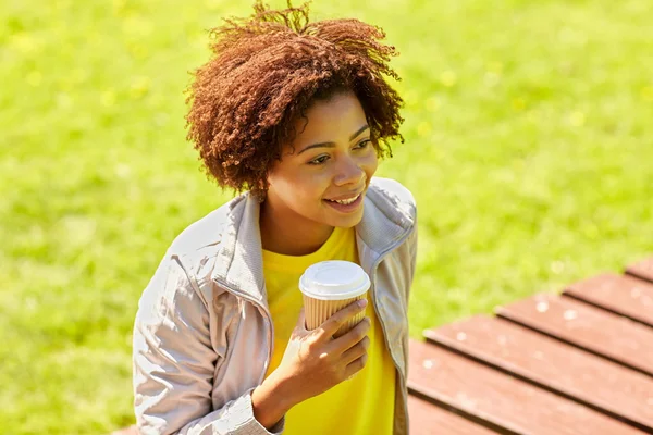 Smiling african woman drinking coffee outdoors — Stock Photo, Image