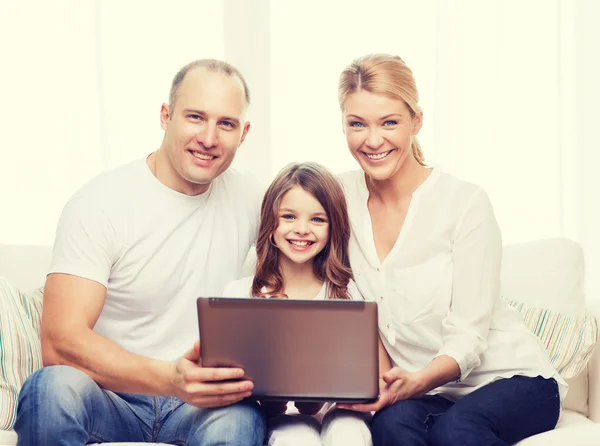 Föräldrar och liten flicka med laptop hemma — Stockfoto