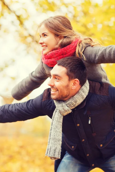 Sonriente pareja divirtiéndose en el parque de otoño — Foto de Stock