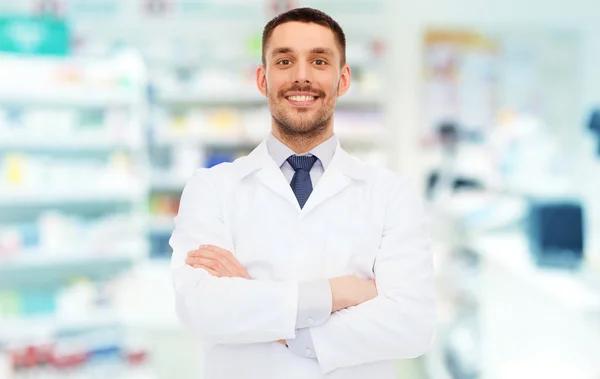 Farmacéutico masculino sonriente con abrigo blanco en la farmacia — Foto de Stock
