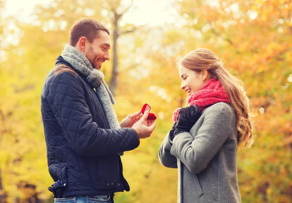 Улыбающаяся пара с обручальным кольцом в подарочной коробке — стоковое фото