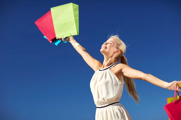 Femme souriante avec sac à provisions levant les mains — Photo