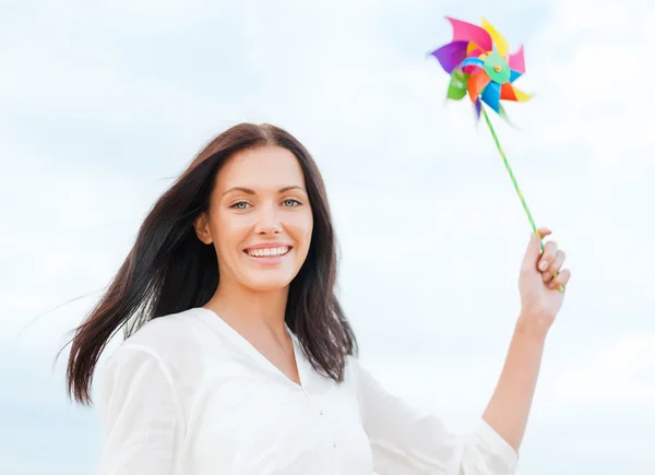 Meisje met windmolen speelgoed op het strand — Stockfoto