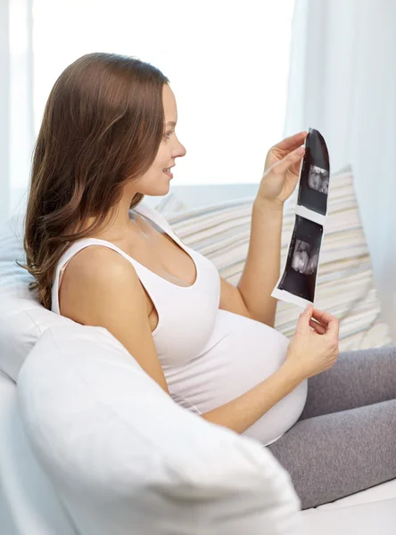 Happy pregnant woman with ultrasound image at home — Stock Photo, Image