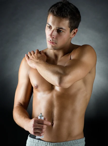 Jonge mannelijke bodybuilder toepassing pijn opluchting gel — Stockfoto