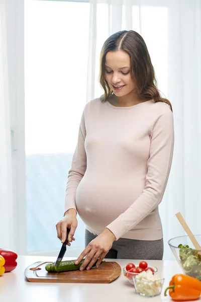 Щаслива вагітна жінка готує їжу вдома — стокове фото