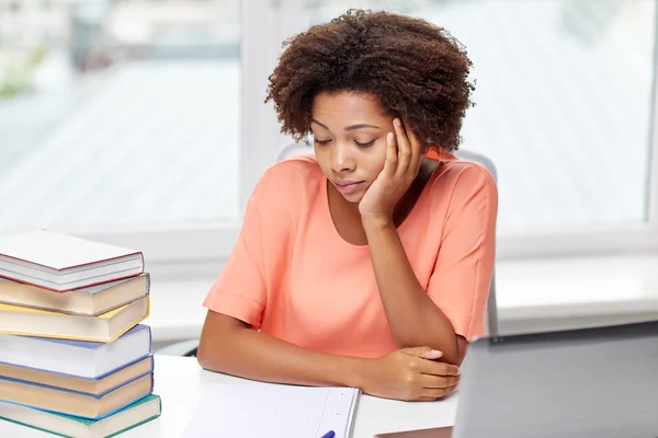 Mujer afroamericana aburrida haciendo la tarea en casa — Foto de Stock