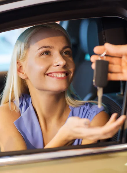 Mulher feliz recebendo chave do carro em auto show ou salão — Fotografia de Stock