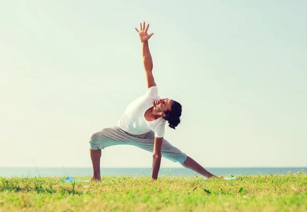 Yoga yaparak gülümseyen adam açık havada egzersiz — Stok fotoğraf