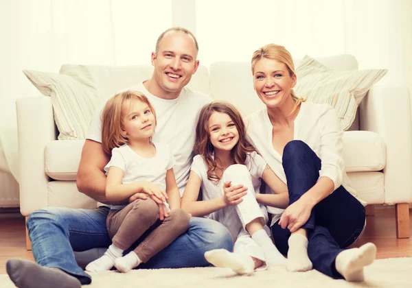 Föräldrar och två tjejer sitter på golvet hemma — Stockfoto