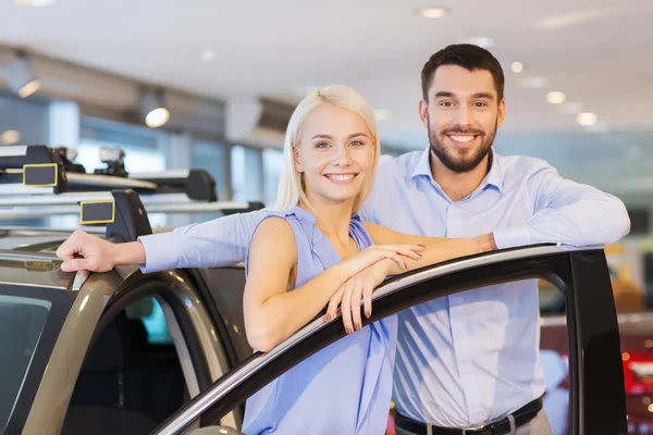 Feliz pareja comprando coche en auto show o salón — Foto de Stock