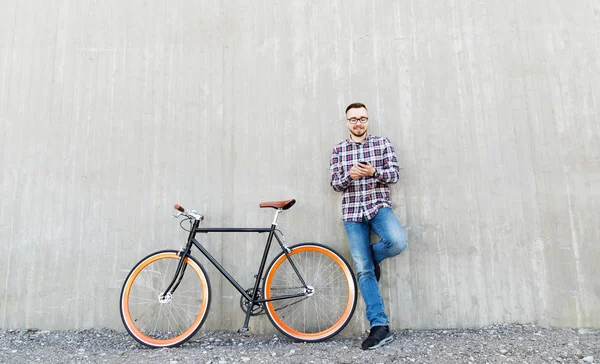 Hipster uomo in auricolare con smartphone e bici — Foto Stock