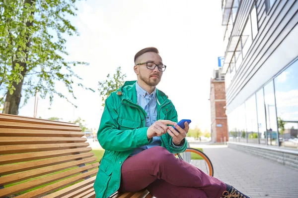 Gelukkig jonge hipster man met smartphone en fiets — Stockfoto