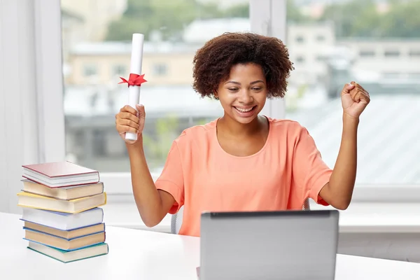 Glückliche Afrikanerin mit Laptop, Büchern und Diplom — Stockfoto
