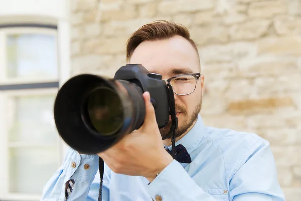 Joven hipster hombre con cámara digital en la ciudad — Foto de Stock