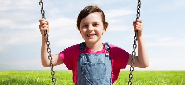 Happy little girl swinging on swing outdoors — Stock Photo, Image