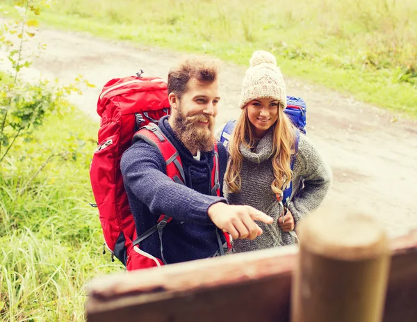 Lachende paar met rugzakken wandelen — Stockfoto