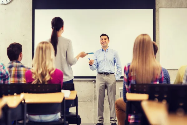 Grupo de estudiantes y profesor sonriente en el aula — Foto de Stock