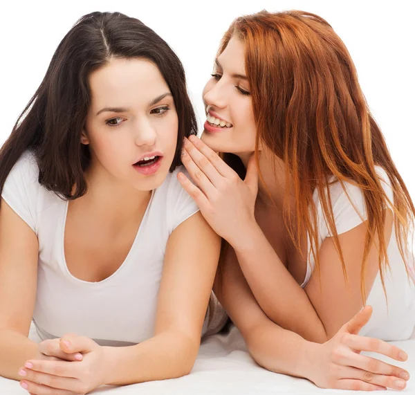 Two smiling girls whispering gossip — Stock Photo, Image