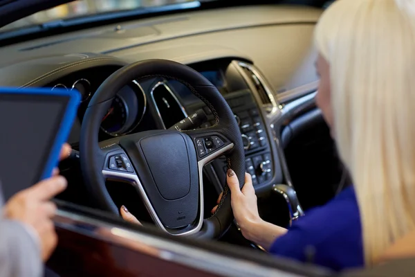 Mujer y concesionario de coches con la tableta PC en el salón de automóviles — Foto de Stock