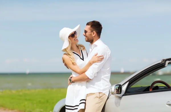 Homem feliz e mulher abraçando perto do carro no mar — Fotografia de Stock