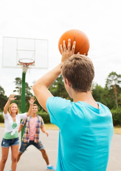 Groep gelukkig tieners spelen basketbal — Stockfoto